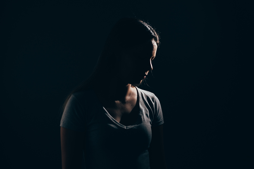 Sad woman in dark room. Depression and anxiety disorder concept